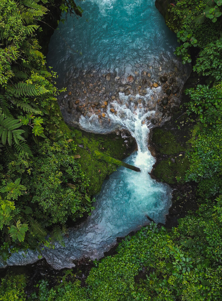 zdjęcie z góry przedstawiające błękitną wodę z wodospadów Blue Falls w Kostaryce